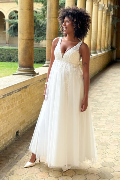 Maternity bridal gown with lace appliqués